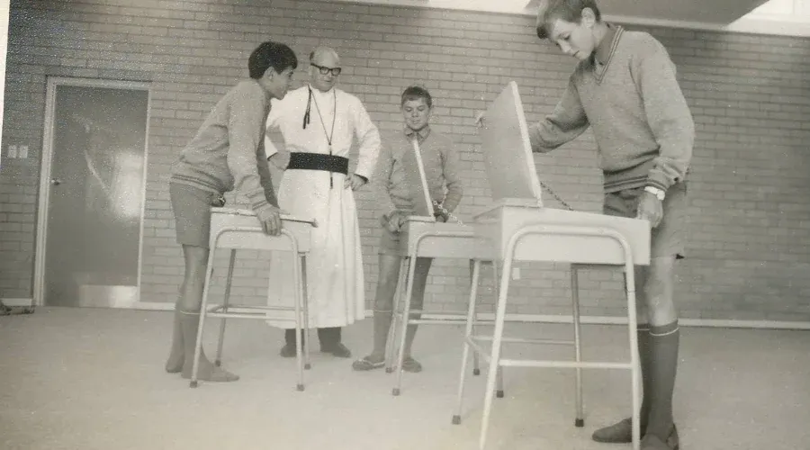 A heritage photo of students admiring their new desks at Mazenod College Perth WA